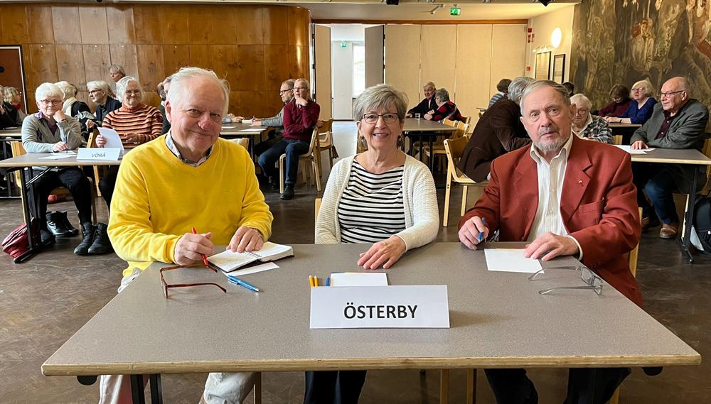 Österbys lag sitter vid bordet i Kårens festsal med glasögon, papper och pennor på bordet.