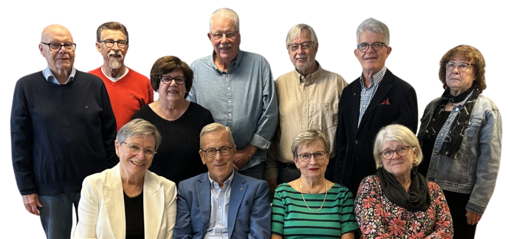 En grupp på elva vuxna, sex män och fem kvinnor, poserar tillsammans för ett foto. Fyra sitter medan resten står bakom dem. Bakgrunden är enfärgad vit.